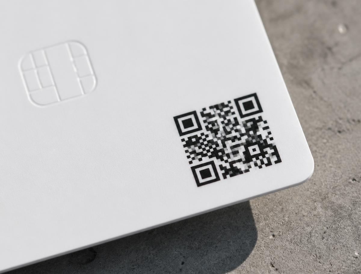 Detalle de la tarjeta blanca mostrando el código QR impreso y el chip NFC
